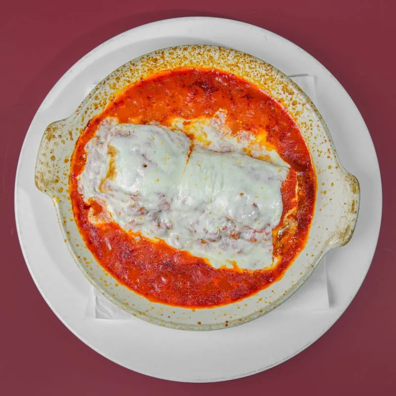 Lasagna baked in a dish under tomato sauce and melted mozzarella