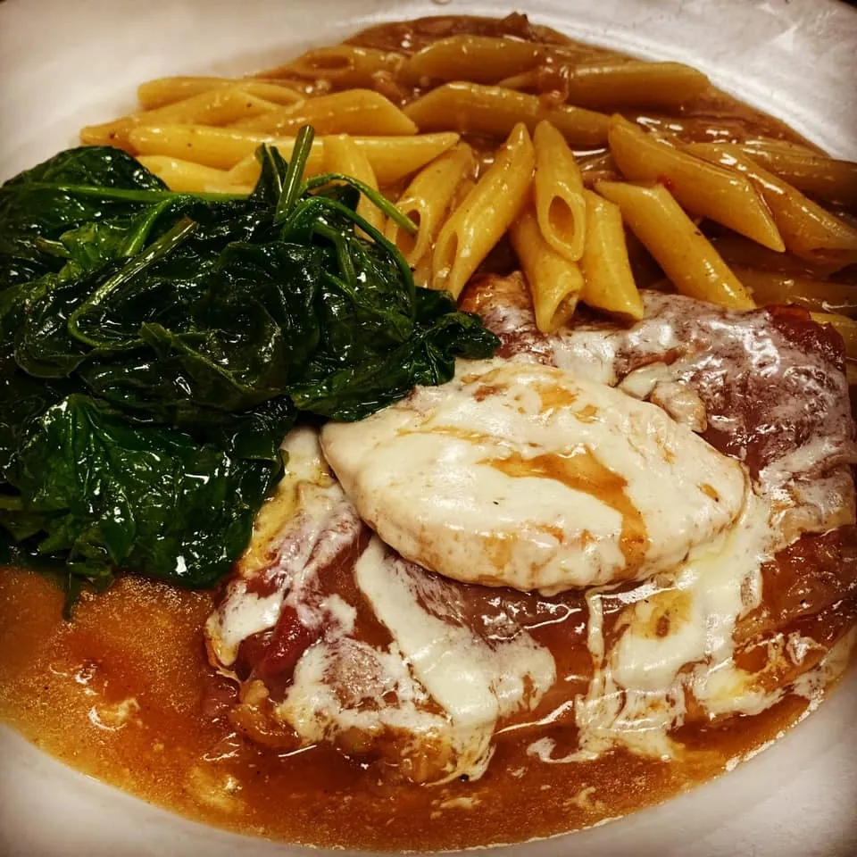 Veal with melted mozzarella, penne in tomato sauce and sauteed spinach